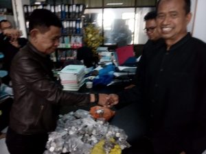 Abdul Jana (kiri), warga Jln. Pasantren, Kota Cimahi, saat menyerahkan uang recehan untuk biaya ujian sidang S-1 anaknya,( Foto: Dede Suherlan/Didikpos.com)